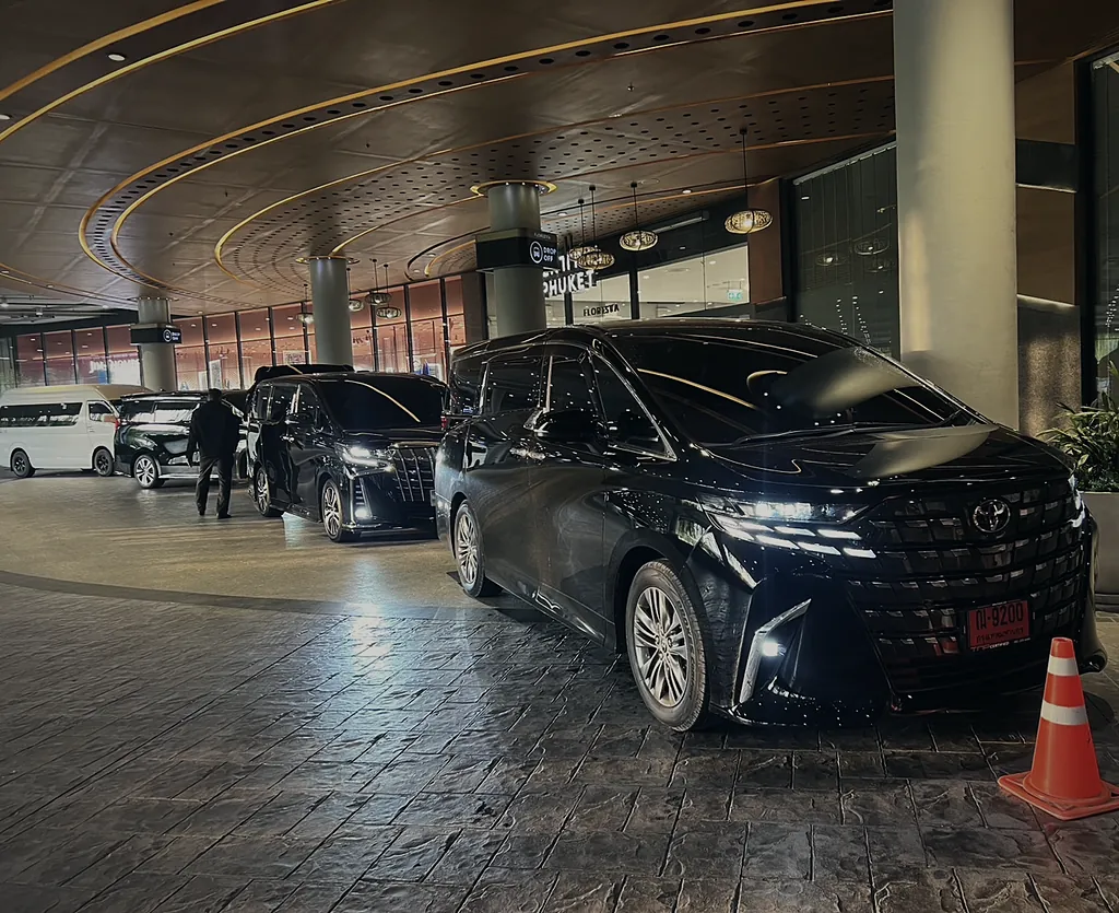 The Alphard with its lights on at a lit entrance in the evening